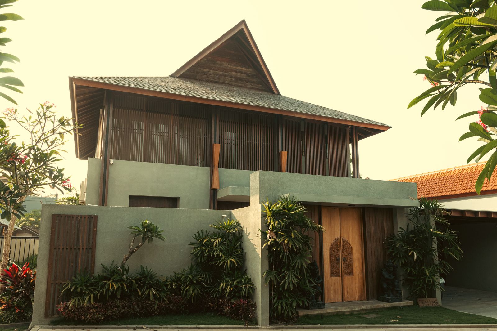 Front of the villa from the lane, with its carved timber gate