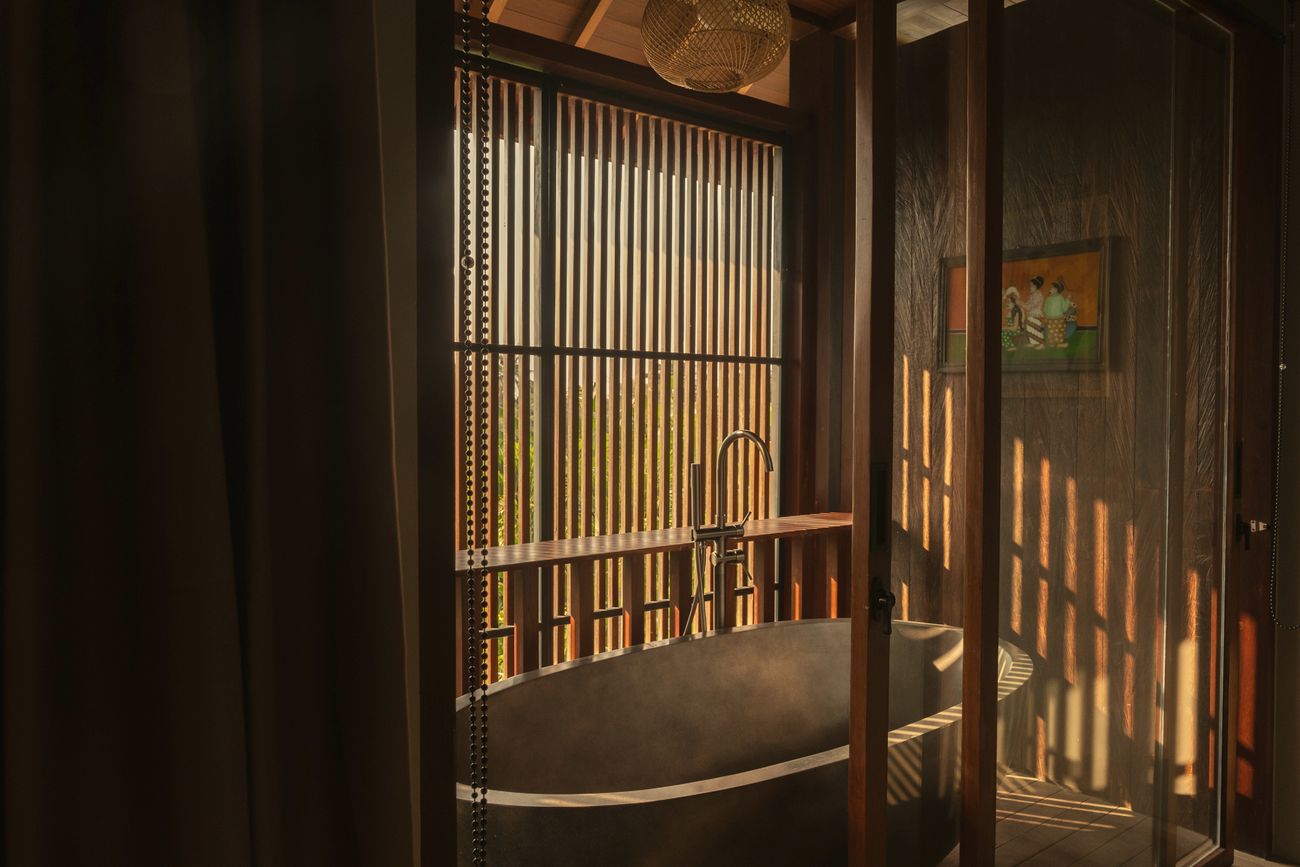 Stone bathtub behind timber screens